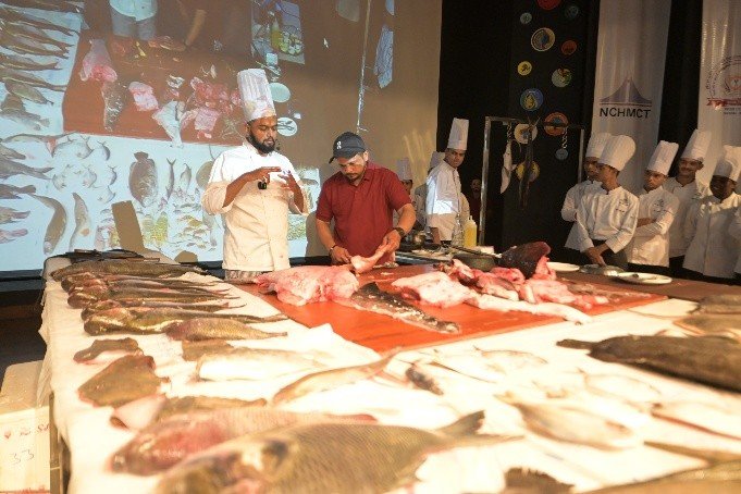 Seafood fabrication demonstration with students watching